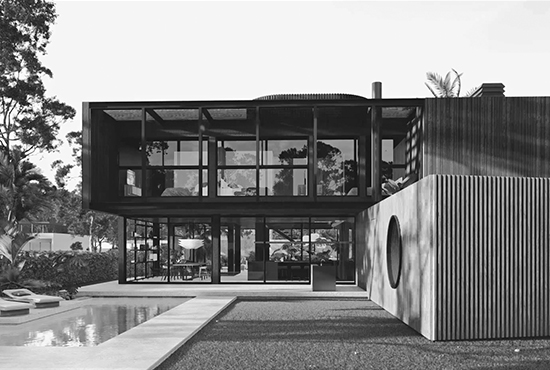 a black and white photo of a house with a pool brauchli house - JVA Renders